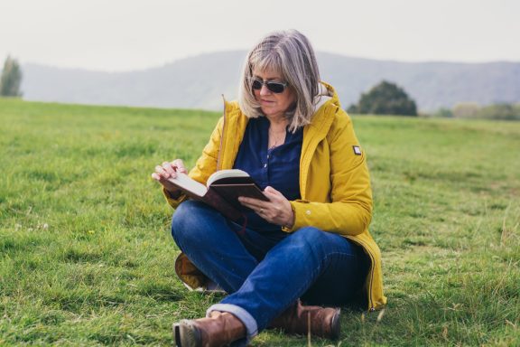 Linzi reading a book outdoors in Malvern